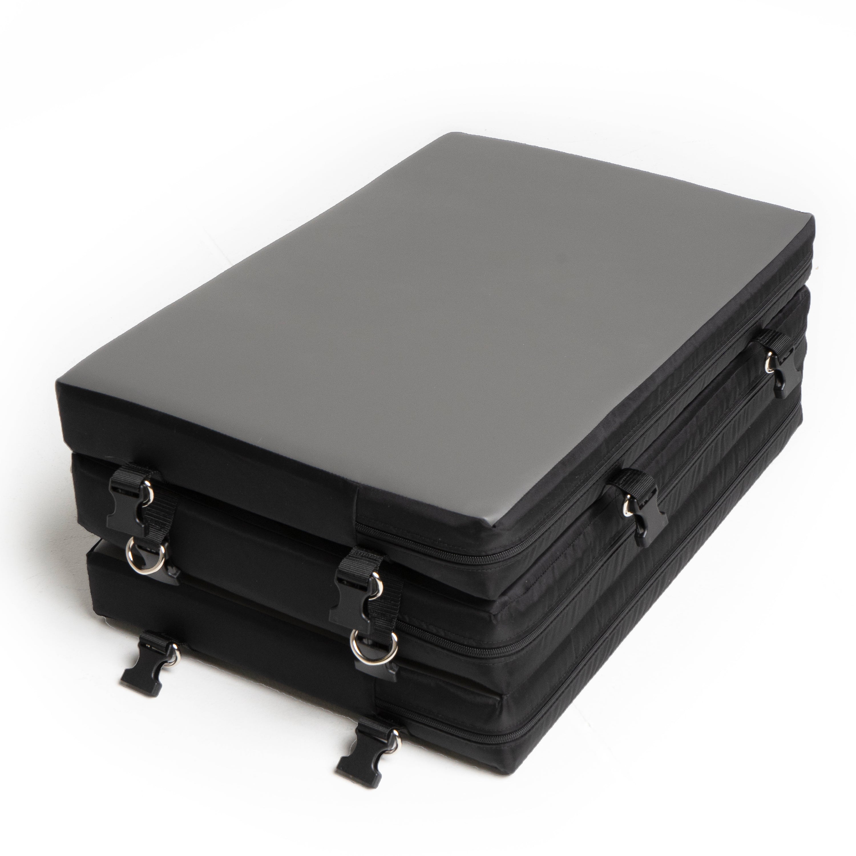 A grey faux leather portable bondage board folded with black straps and buckles.