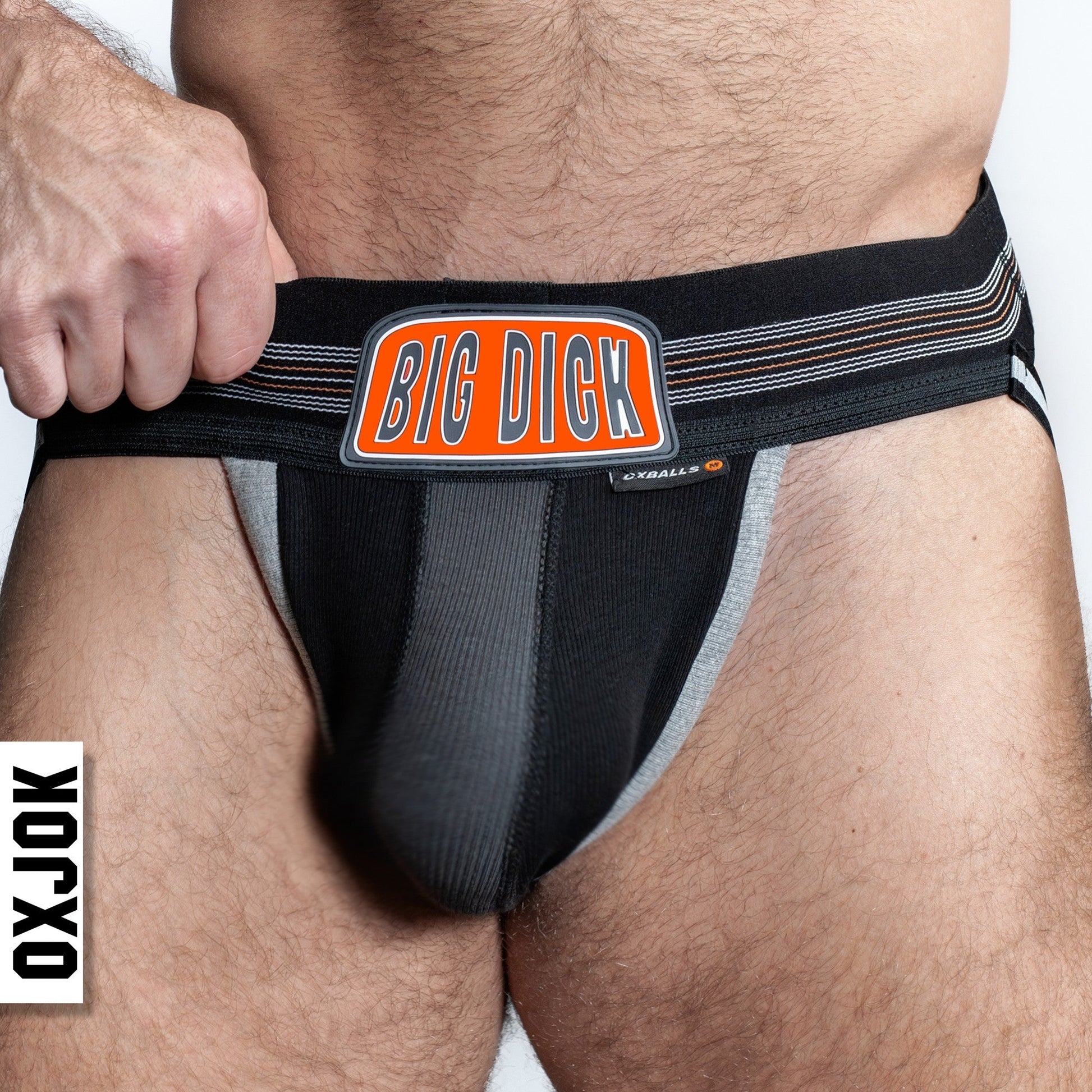 Black and grey jockstrap with "BIG DICK" logo and white text "OXJOK".