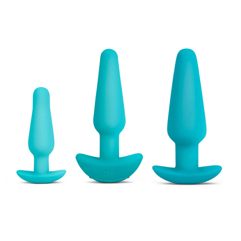 Three teal silicone butt plugs of varying sizes on a white background.