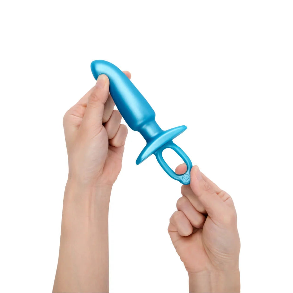 Blue silicone prostate plug with a retrieval ring held by two hands.