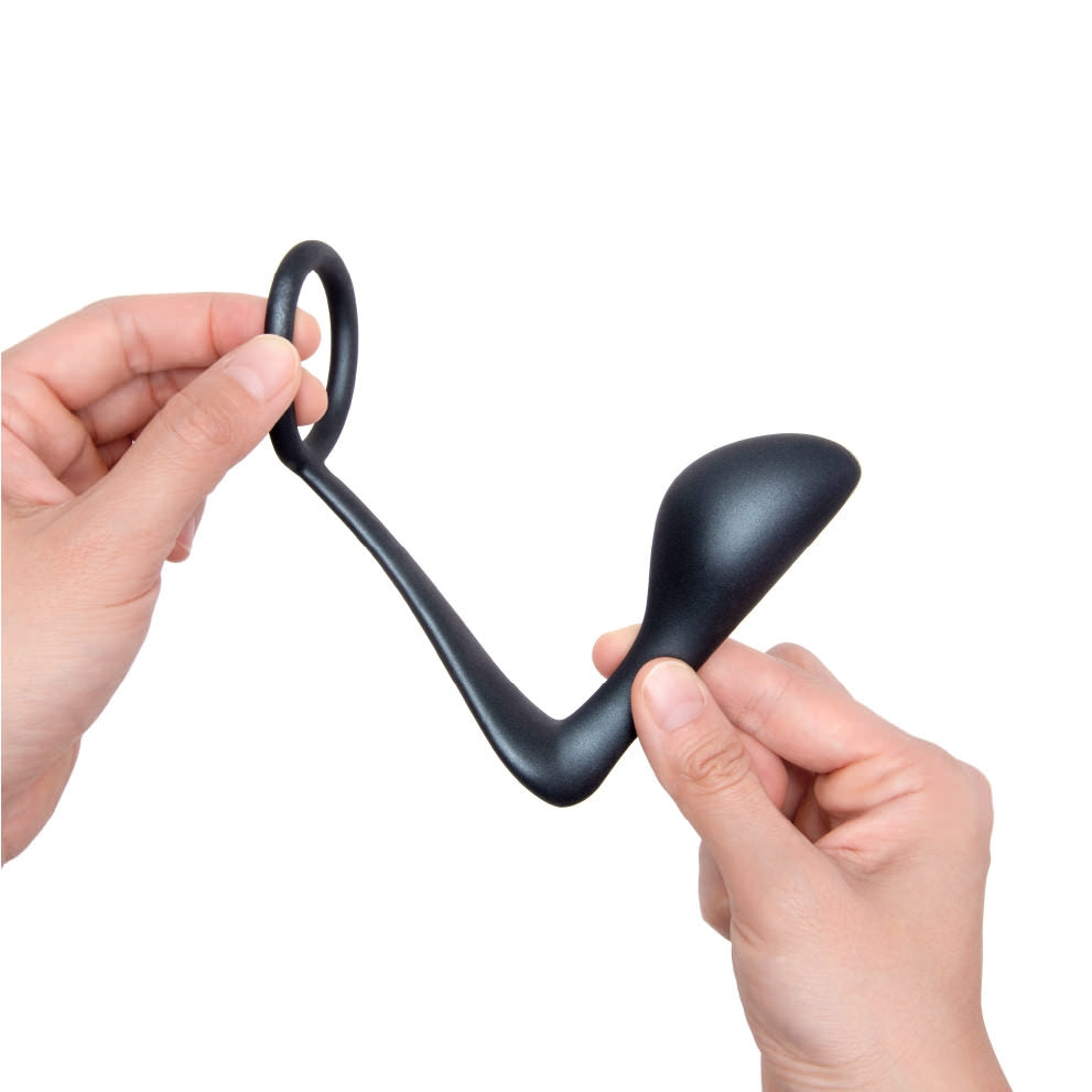 Black silicone cock ring and prostate plug held by two hands.