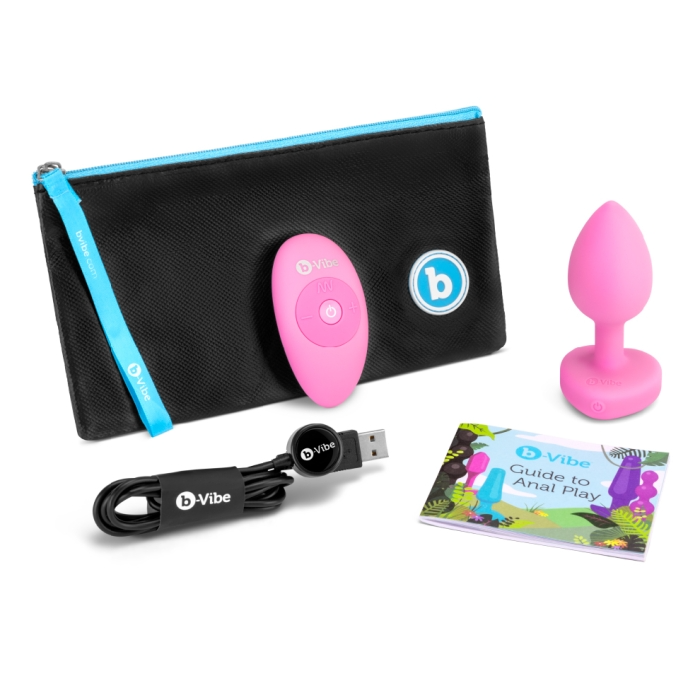 Pink silicone anal plug with remote, USB cable, and instruction booklet.