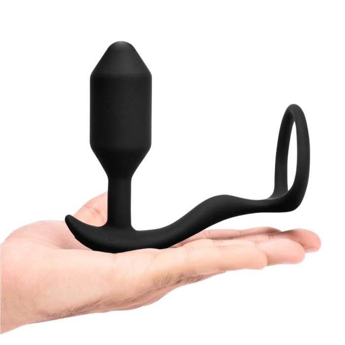 Black vibrating weighted butt plug and penis ring held in a hand.