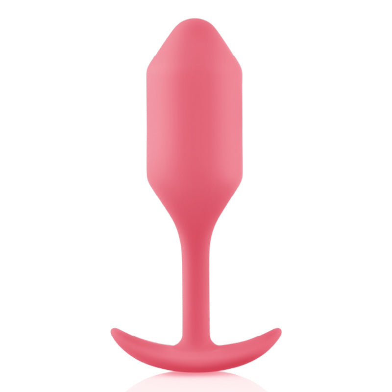 A coral weighted silicone anal plug with a flared base.