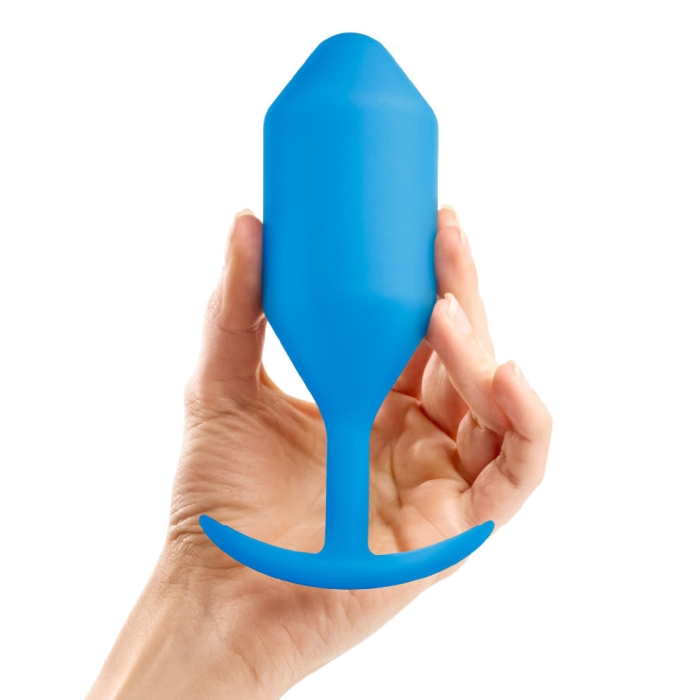 Blue weighted silicone anal butt plug held in a hand.