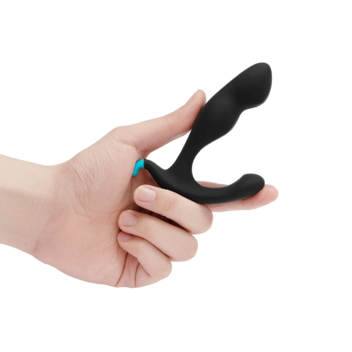 A black silicone prostate massager with a blue accent held in a hand.