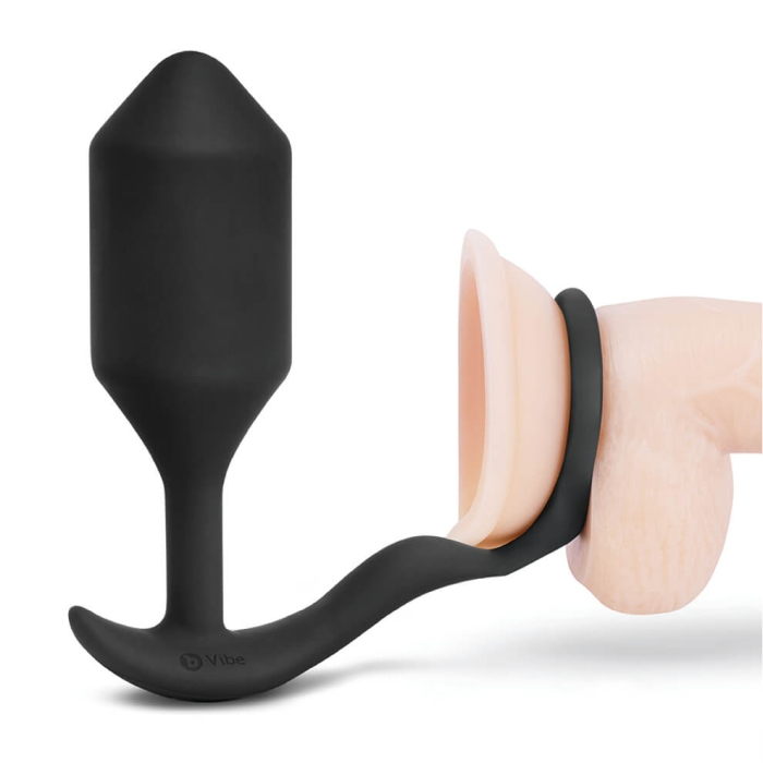 Black silicone weighted anal plug with a cock ring attached.