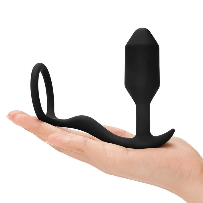 Black silicone weighted anal plug and cock ring on a hand.