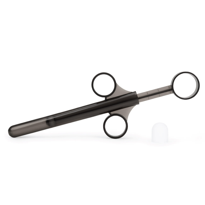 A black lube applicator with finger loops and a white cap.