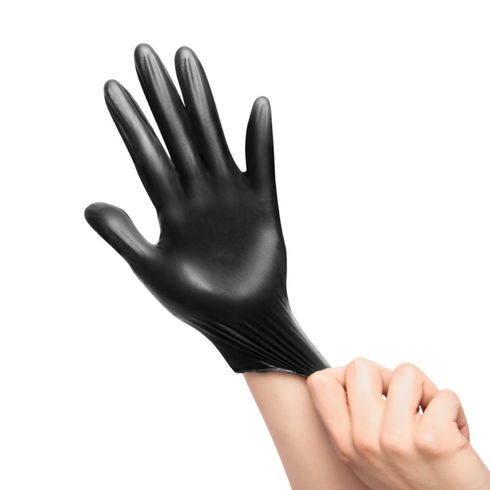 Black nitrile glove being pulled onto a hand.