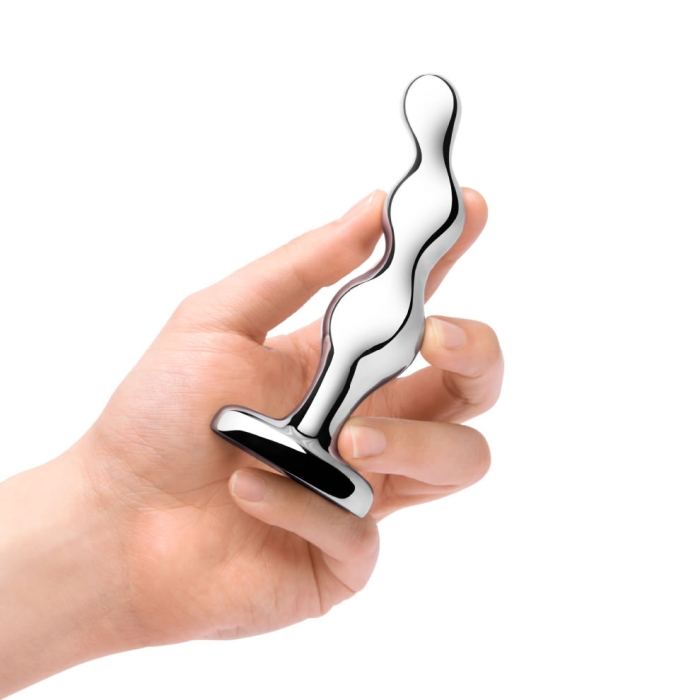 A hand holds a shiny, silver, graduated anal bead toy.
