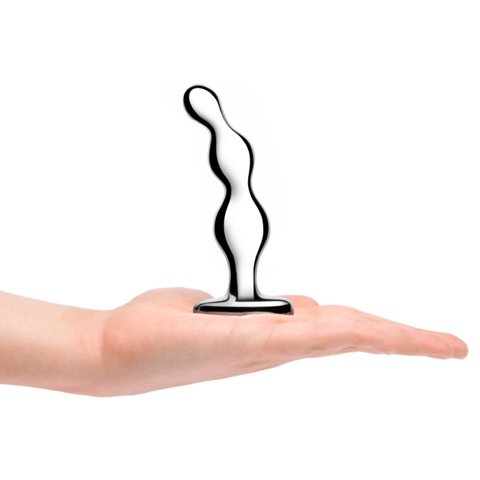 A silver, curved anal toy rests on an open palm.