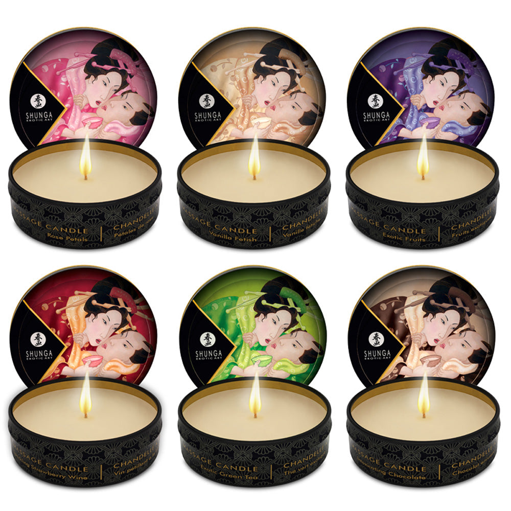Six Shunga massage candles with erotic artwork and lit wicks.