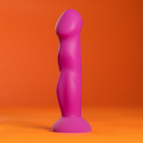 Violet dual-density silicone G-spot toy with curved shaft and flared base on orange background.