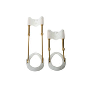 Two white and gold penis extenders of different sizes.