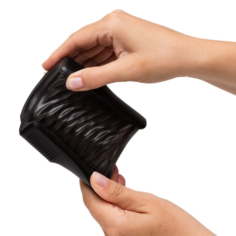 Black silicone vibrating open sleeve masturbator being squeezed by hands.