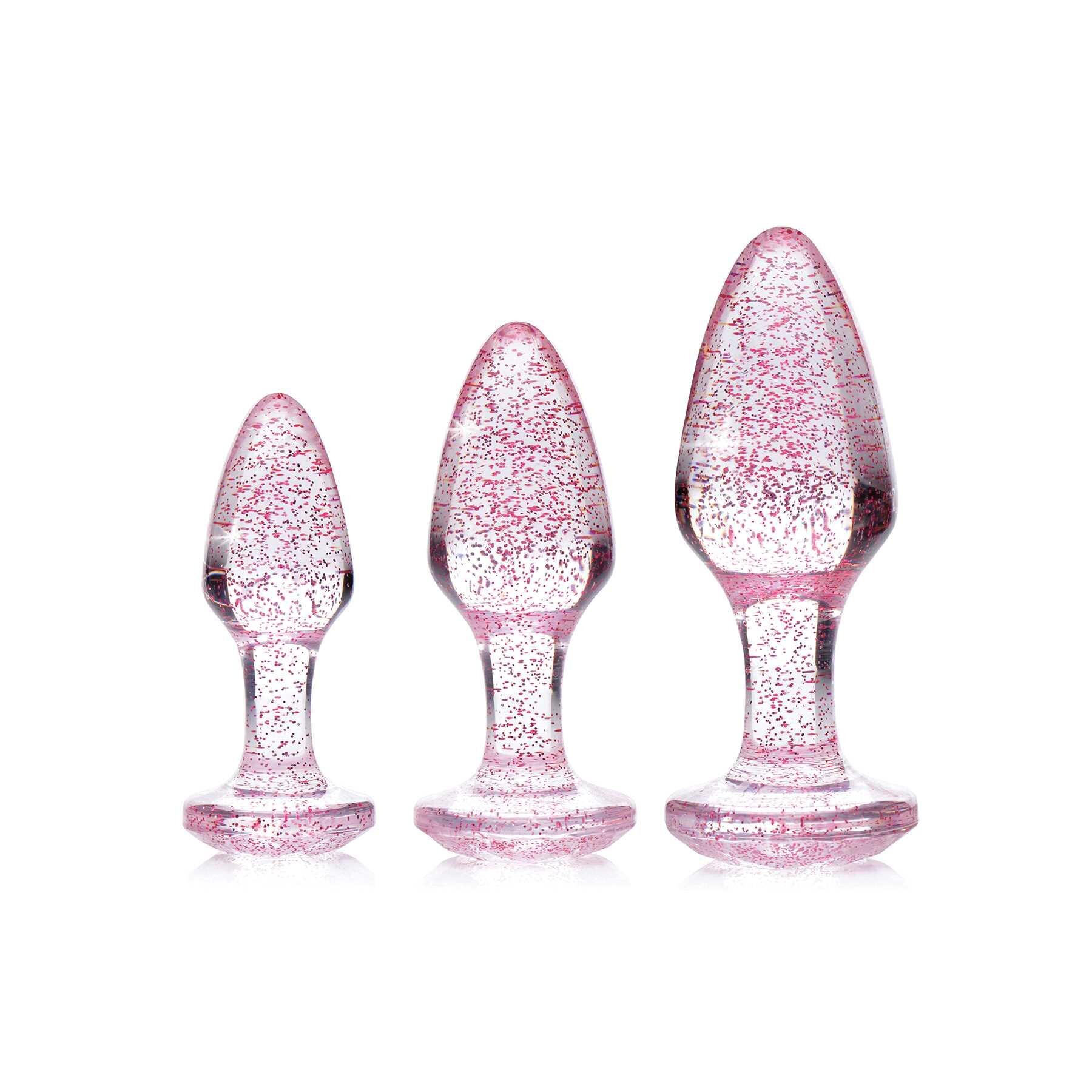Three pink glitter anal plugs of varying sizes.
