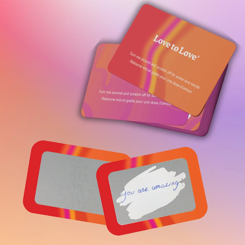 A stack of "Love to Love" scratch-off cards and two cards with scratch-off areas, one with "You are amazing!" written on it.
