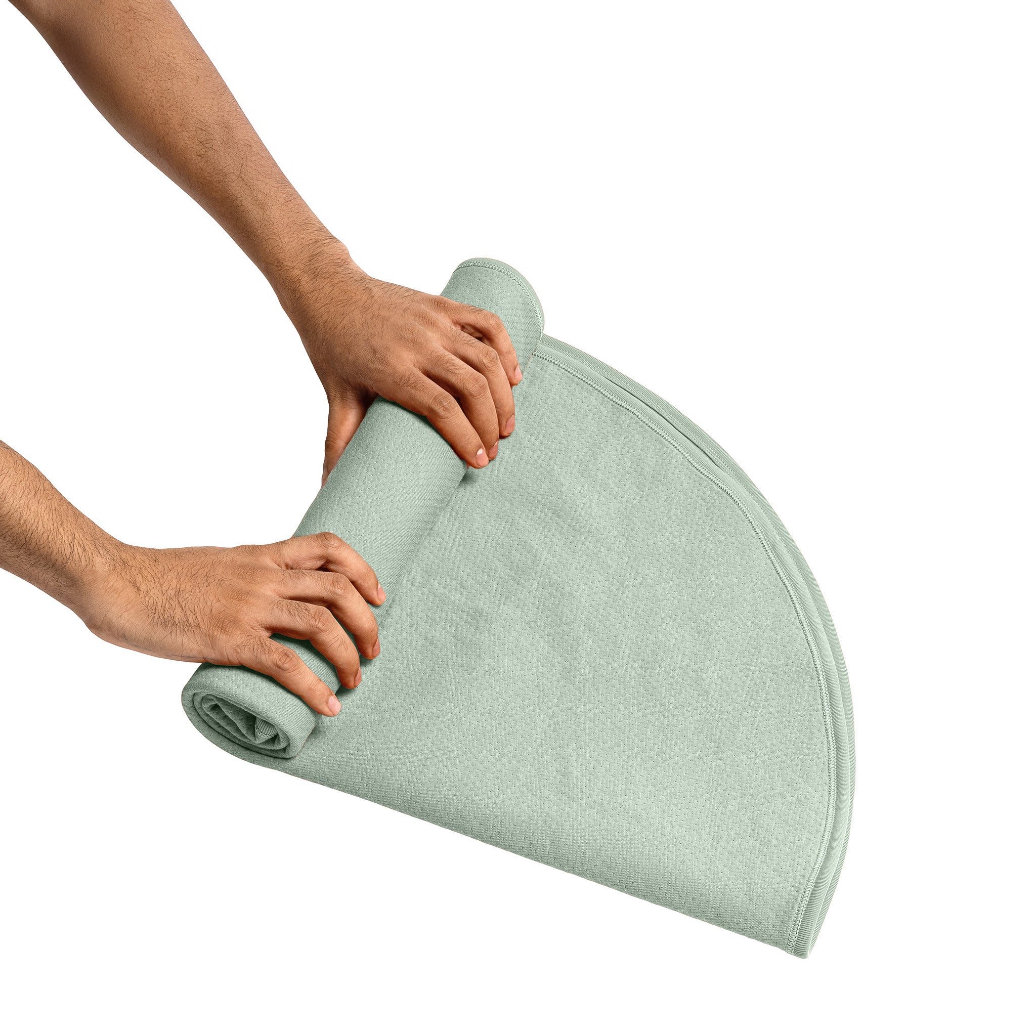 Sage green waterproof cotton sex blanket being rolled up.