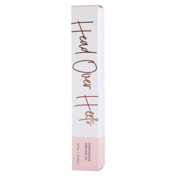 A white and pink box with "Head Over Heels" and "Pheromone Perfume Oil" printed on it.