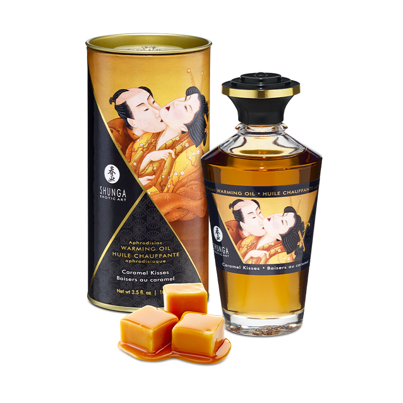 Shunga Caramel Kisses edible warming massage oil in a bottle and tube with caramel candies.