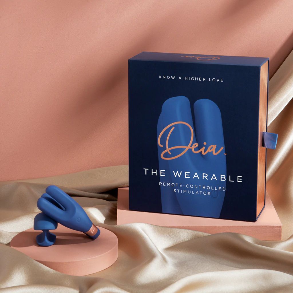 A blue wearable remote-controlled vibrator and its navy blue box.