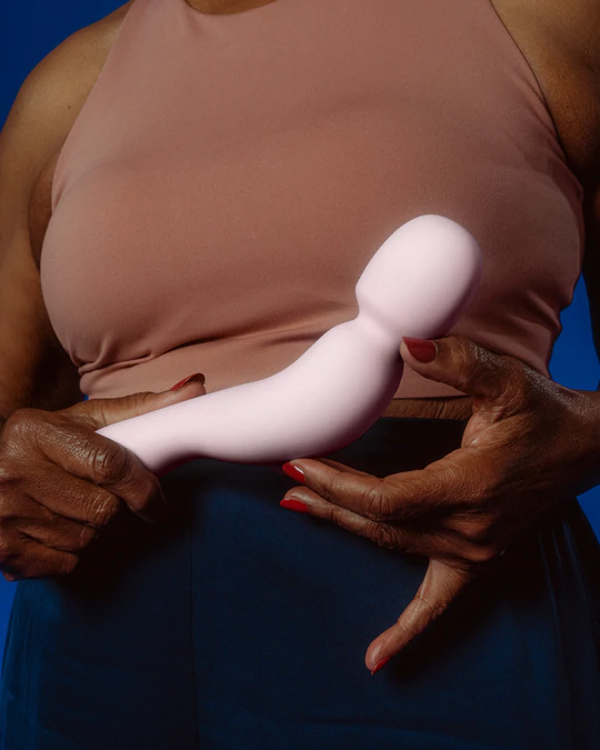 A pink silicone wand vibrator held by hands.