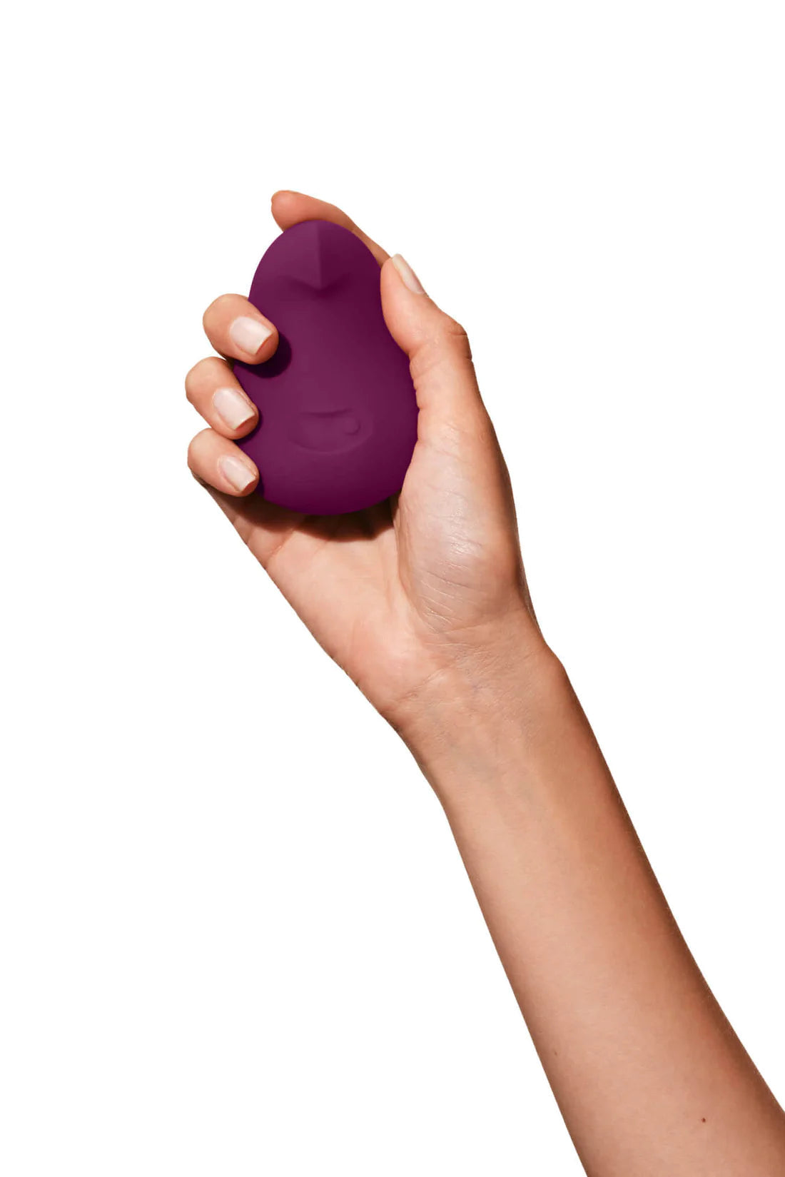 A plum-colored flexible silicone vibrator held in a hand.