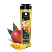 Organica Luscious Mango massage oil bottle with mango fruit and slices.