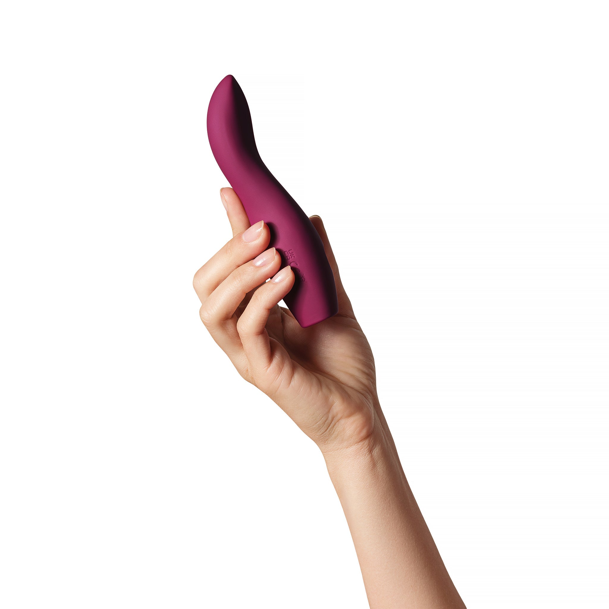 A plum-colored silicone vibrator held in a hand.