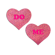 Pink glitter heart nipple pasties with "DO" and "ME" text.
