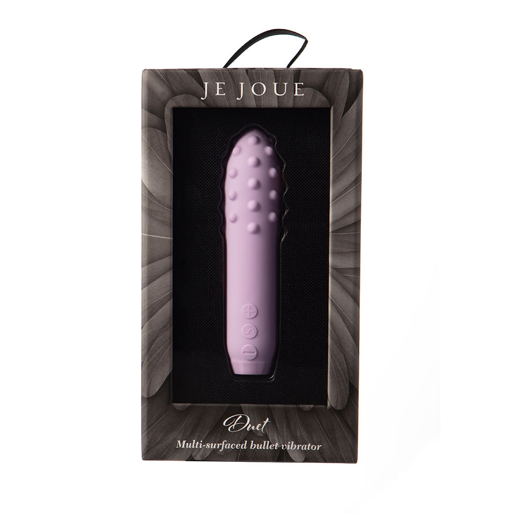 A lilac silicone bullet vibrator with raised bumps and control buttons in its packaging.