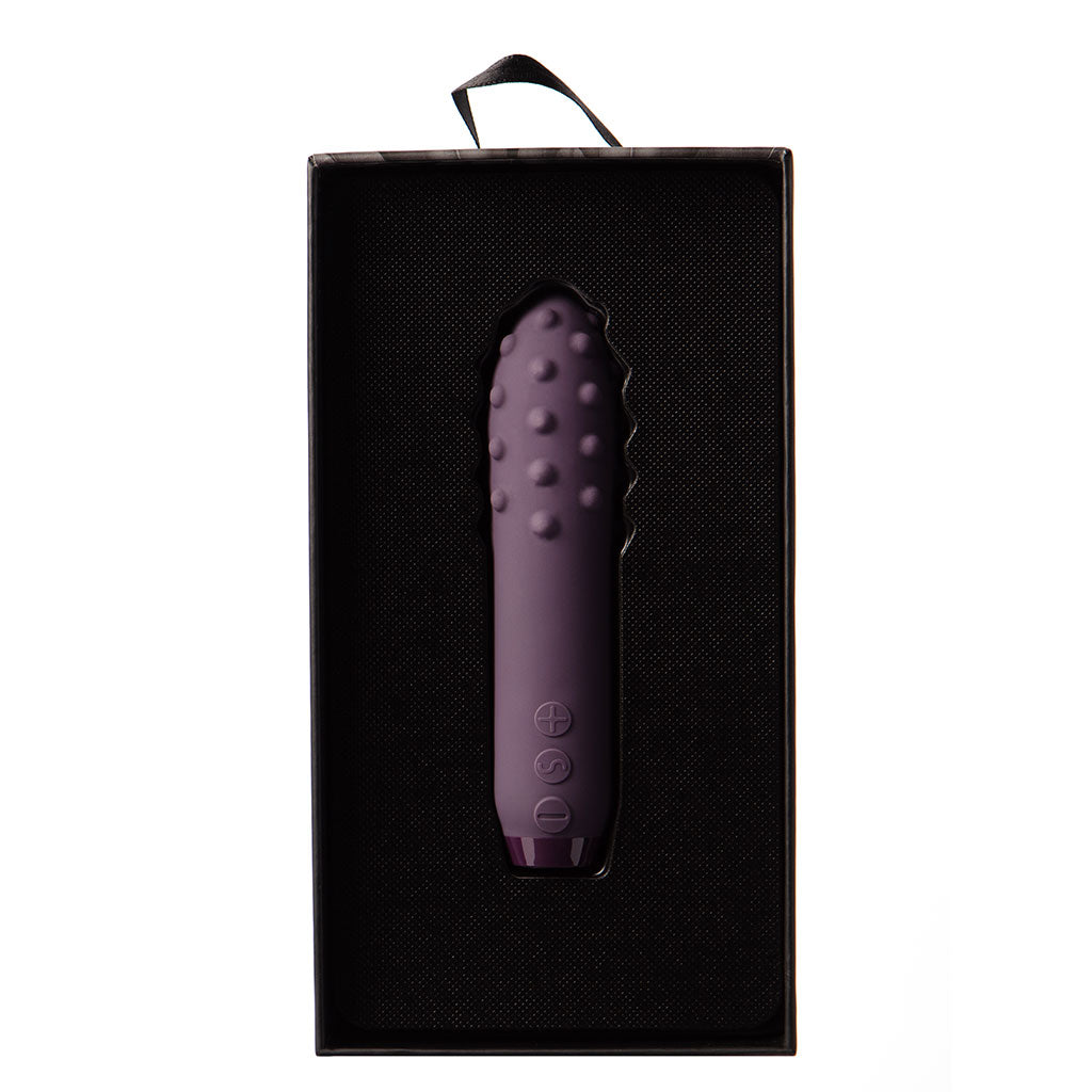 Purple silicone bullet vibrator with textured surface and control buttons in a black box.