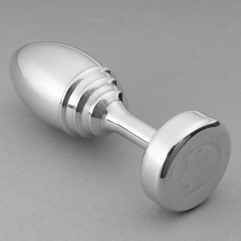 A silver ribbed metal butt plug with a flat base.