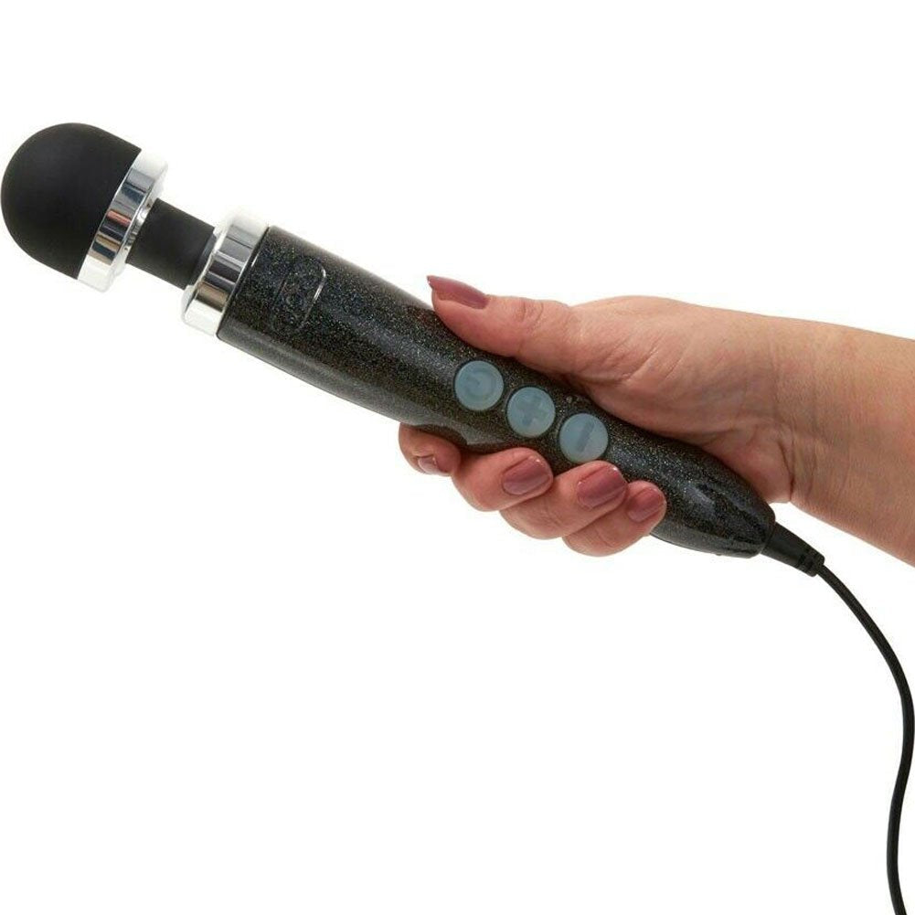 A hand holds a black wand massager with silver accents and three blue buttons.