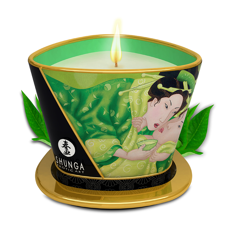A Shunga massage candle with a green tea design and a lit wick.
