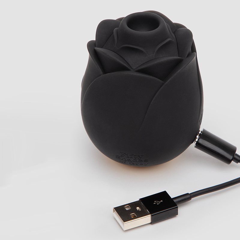 Black rose-shaped vibrator with USB charging cable.