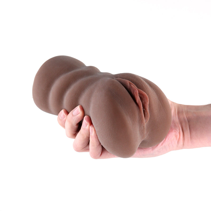 Brown realistic TPE stroker held in a hand.