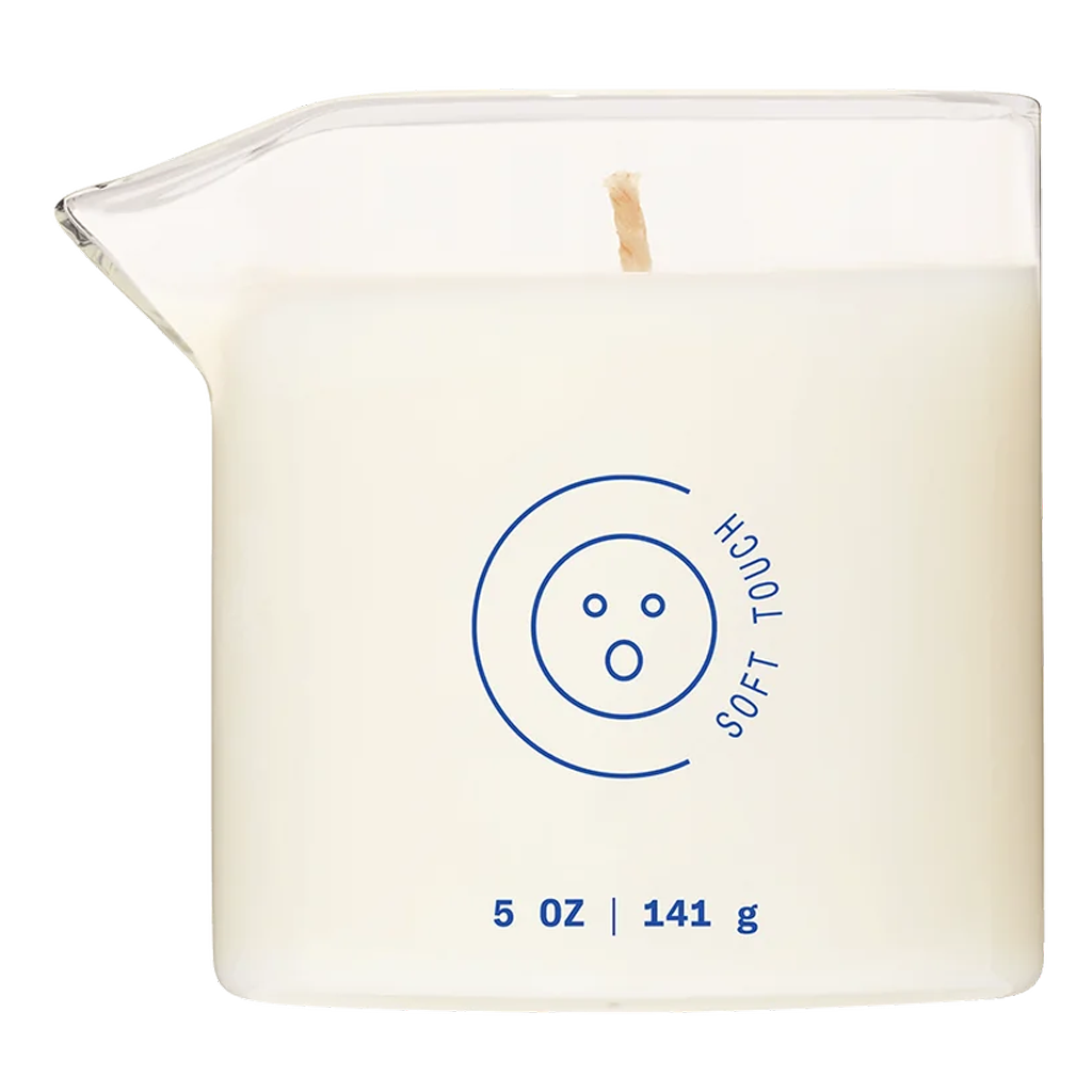 A white massage oil candle in a glass container with a blue logo.