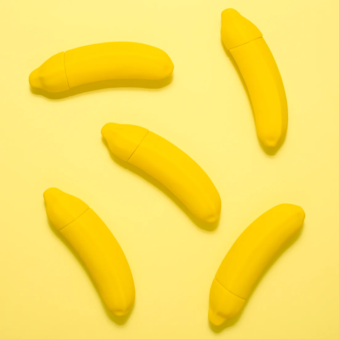 Yellow banana-shaped vibrator with a cap.