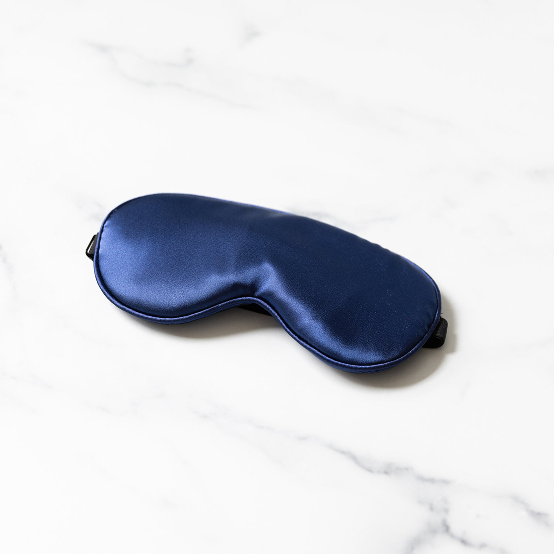A midnight blue satin sleep mask and bondage blindfold.