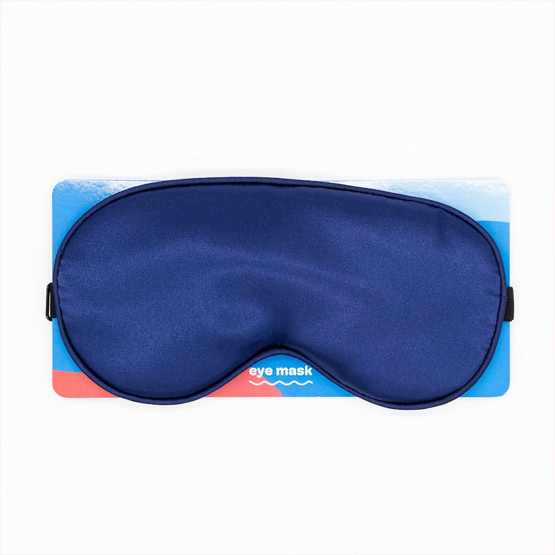A midnight blue satin eye mask on a blue and red card.