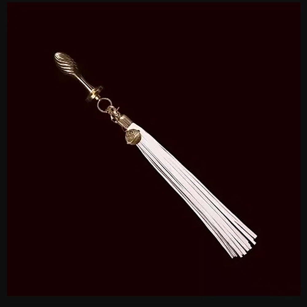 Gold-plated anal plug with a detachable white leather flogger tail.