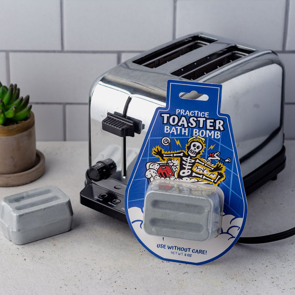 A novelty toaster bath bomb in packaging next to a real toaster.