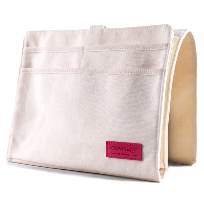 A cream canvas bedside caddy with four pockets and a pink logo.