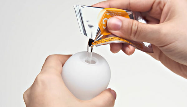 Tenga Thunder Male Masturbator Egg with Super Stretch Sleeve pouring lubricant.