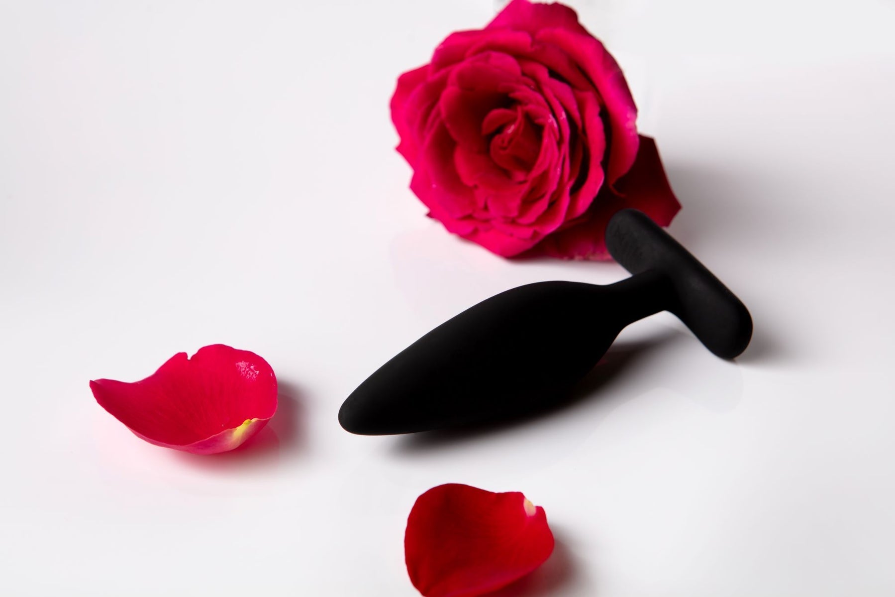Black silicone vibrating anal plug with a rose and petals.