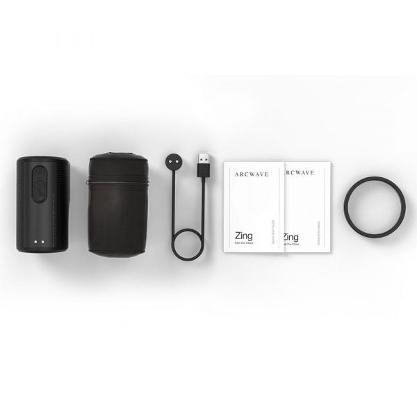 Black vibrating masturbator with charging cable, case, and manuals.