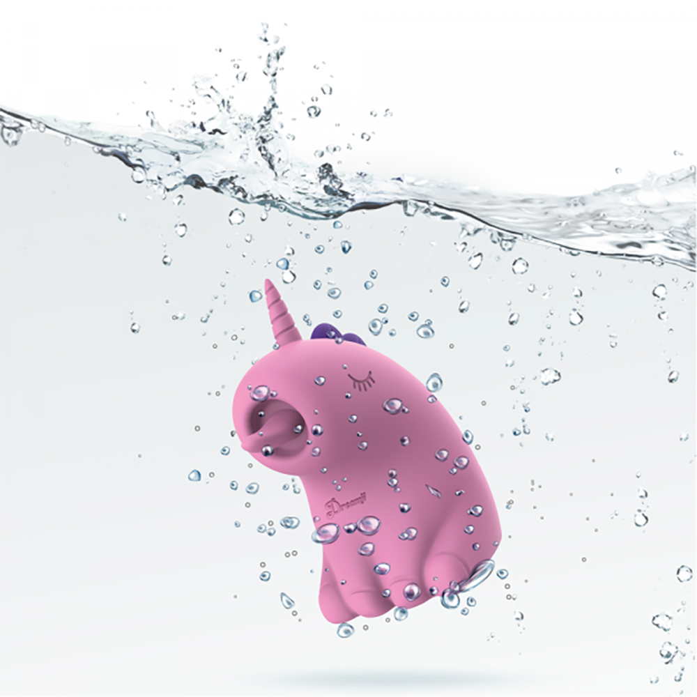 Pink unicorn vibrator with a horn and closed eyes, submerged in water with bubbles.