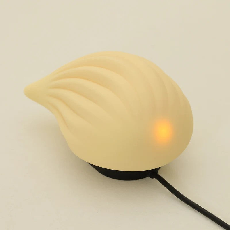 A ribbed, cream-colored silicone vibrator with a warm orange light.